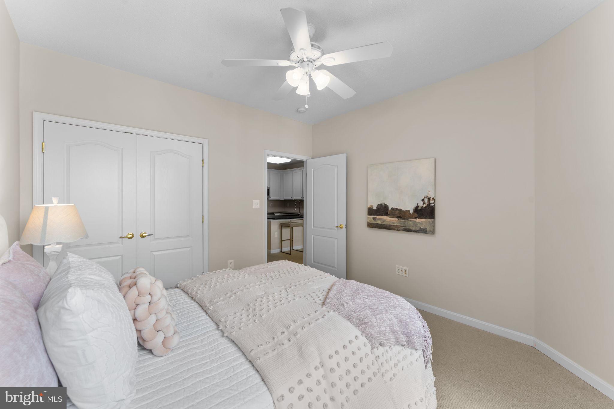12170 Abington Hall Place, Unit 201 Reston, VA 20190 - Photo 19 of 39 a bedroom with a white bed and a chandelier