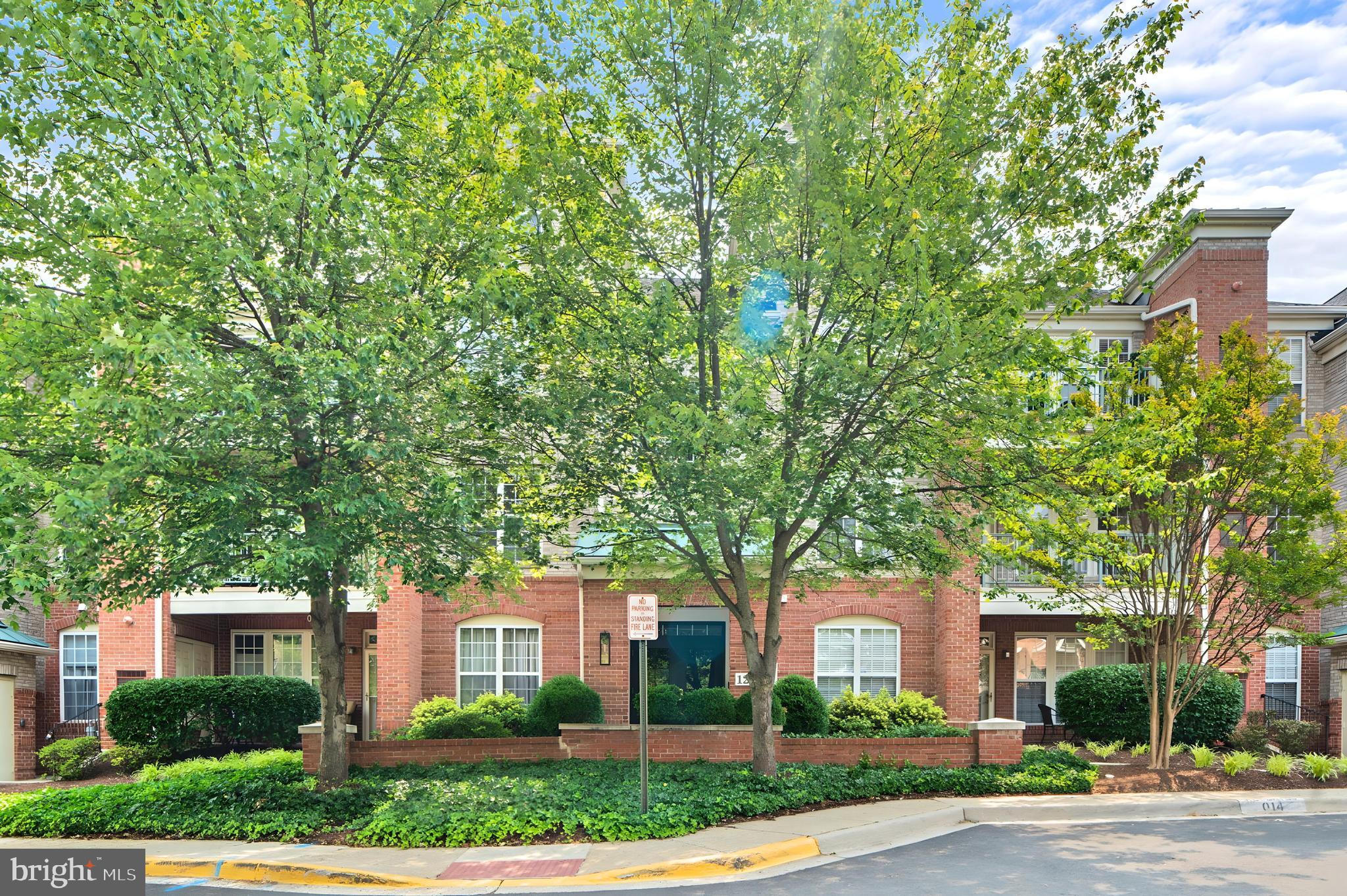 12170 Abington Hall Place, Unit 201 Reston, VA 20190 - Photo 25 of 39 a front view of a house with a yard and potted plants
