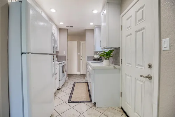 a kitchen with white cabinets and white appliances
