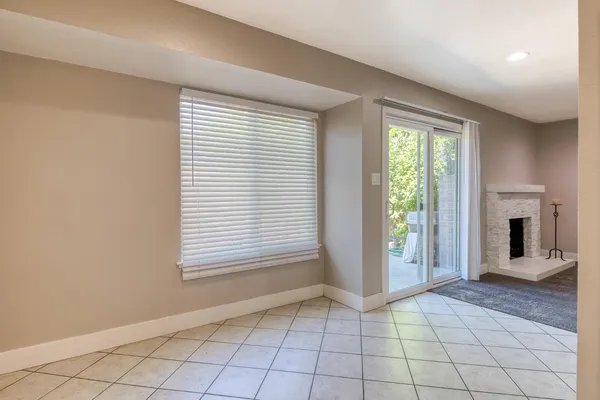 a view of an empty room with window and fire place