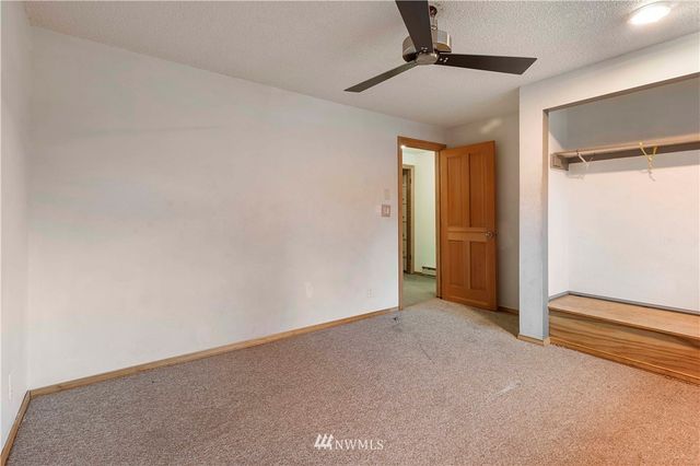 an empty room with a ceiling fan and windows