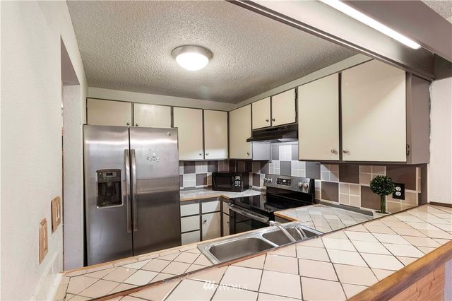 a kitchen with a sink stove top oven and cabinets