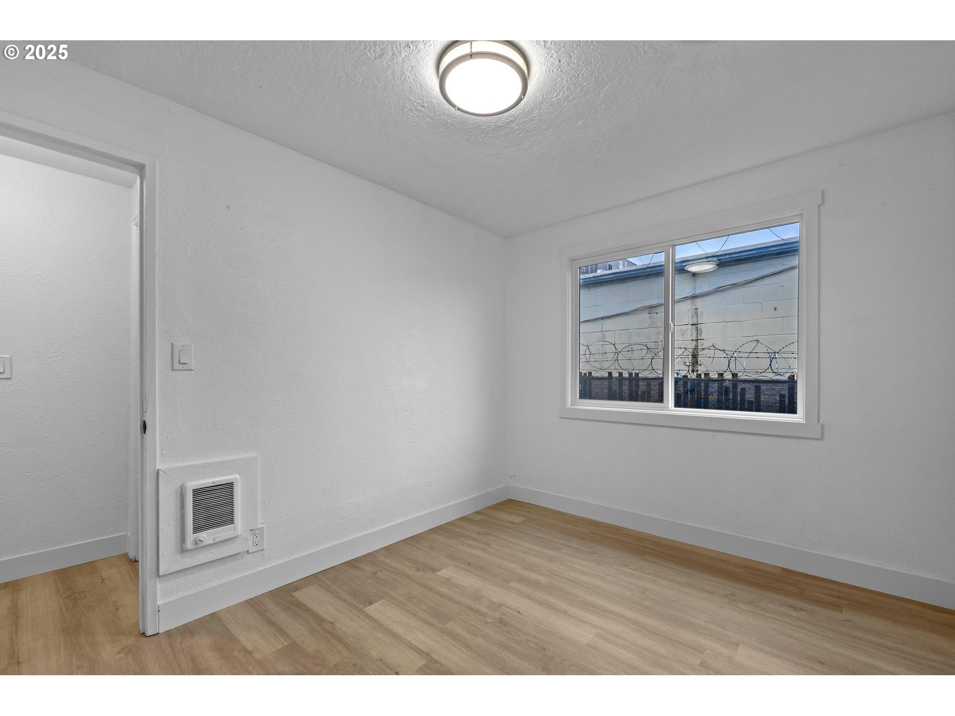 4804-4806 Northeast 111th Avenue Portland, OR 97220 - Photo 11 of 44 a view of an empty room with wooden floor and a window