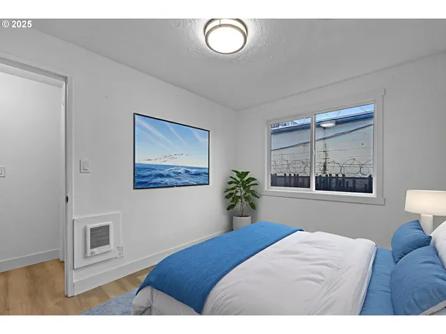 a bedroom with a bed and a painting on the wall