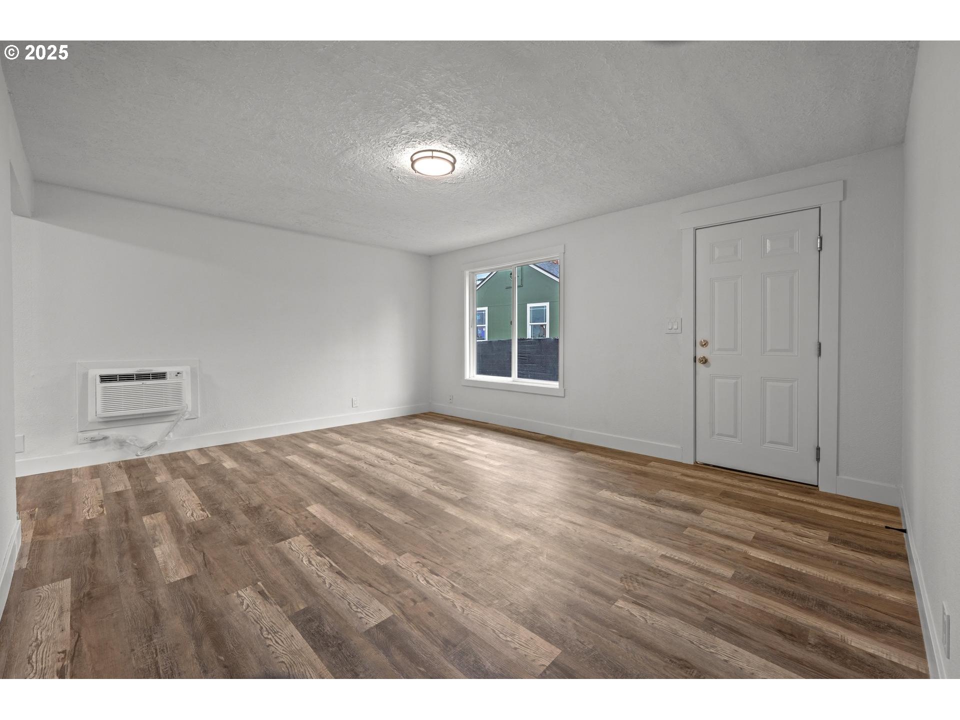 4804-4806 Northeast 111th Avenue Portland, OR 97220 - Photo 19 of 44 a view of an empty room with wooden floor and a window