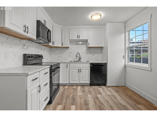 a kitchen with stainless steel appliances granite countertop a sink a stove and cabinets