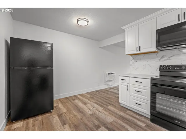 a kitchen with a refrigerator and a stove top oven