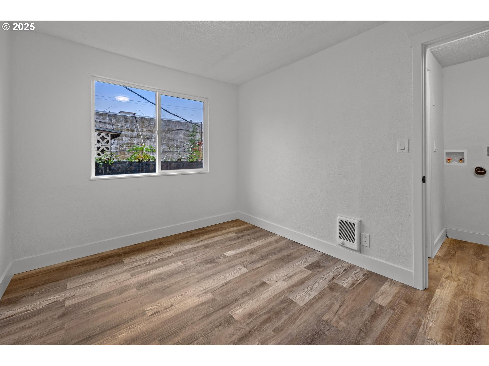 4804-4806 Northeast 111th Avenue Portland, OR 97220 - Photo 30 of 44 a view of an empty room with wooden floor and a window