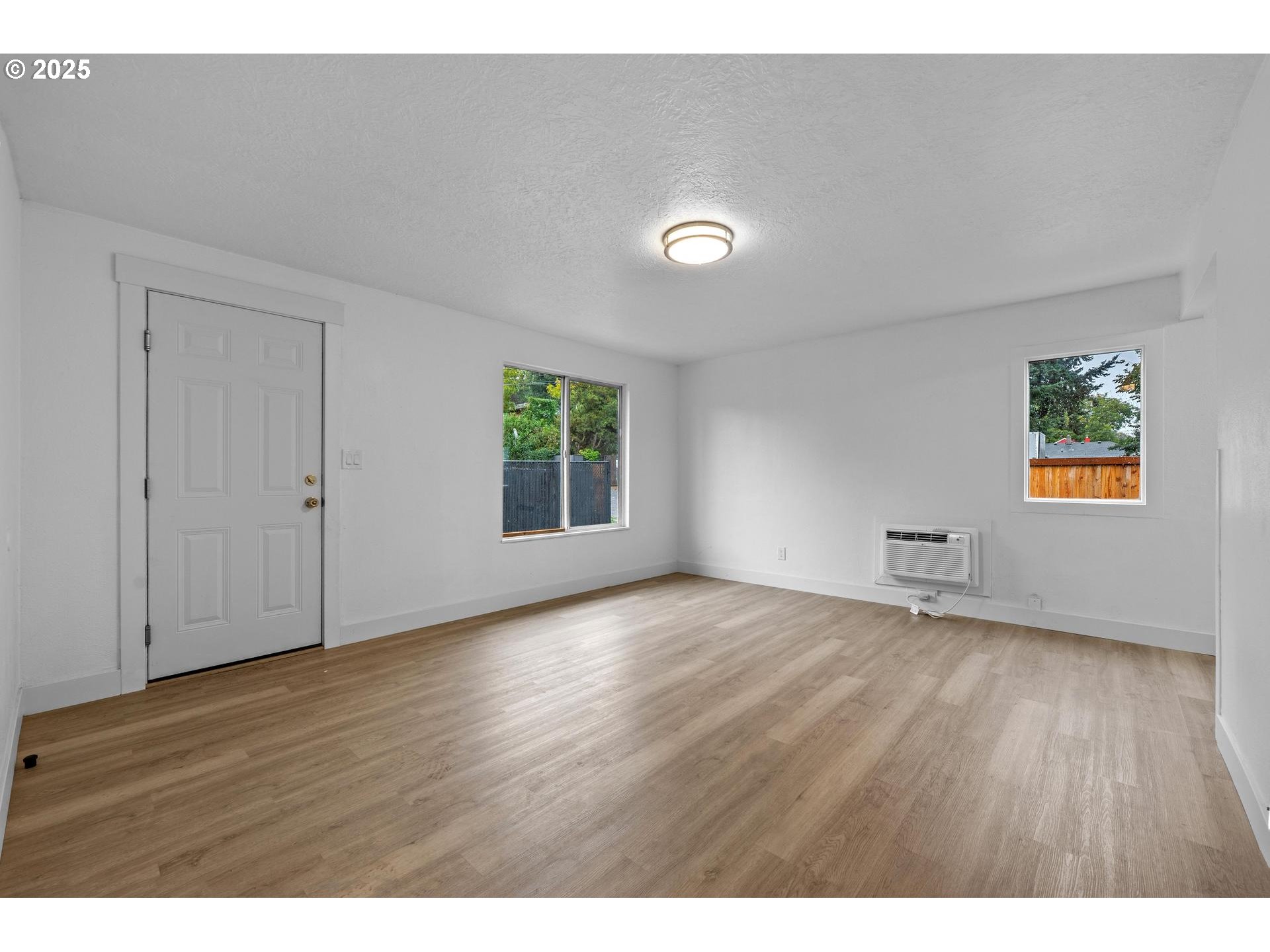 4804-4806 Northeast 111th Avenue Portland, OR 97220 - Photo 3 of 44 a view of an empty room with window and wooden floor