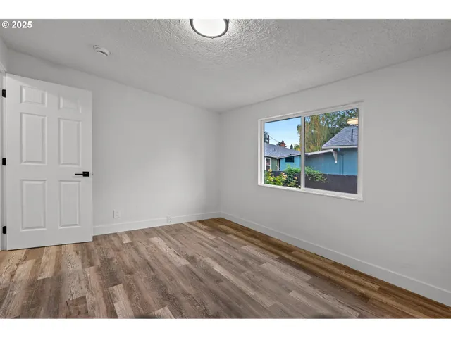 a view of an empty room with window and air conditioner