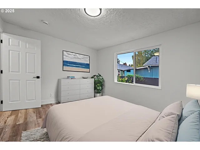 a bedroom with a bed and a painting on the wall