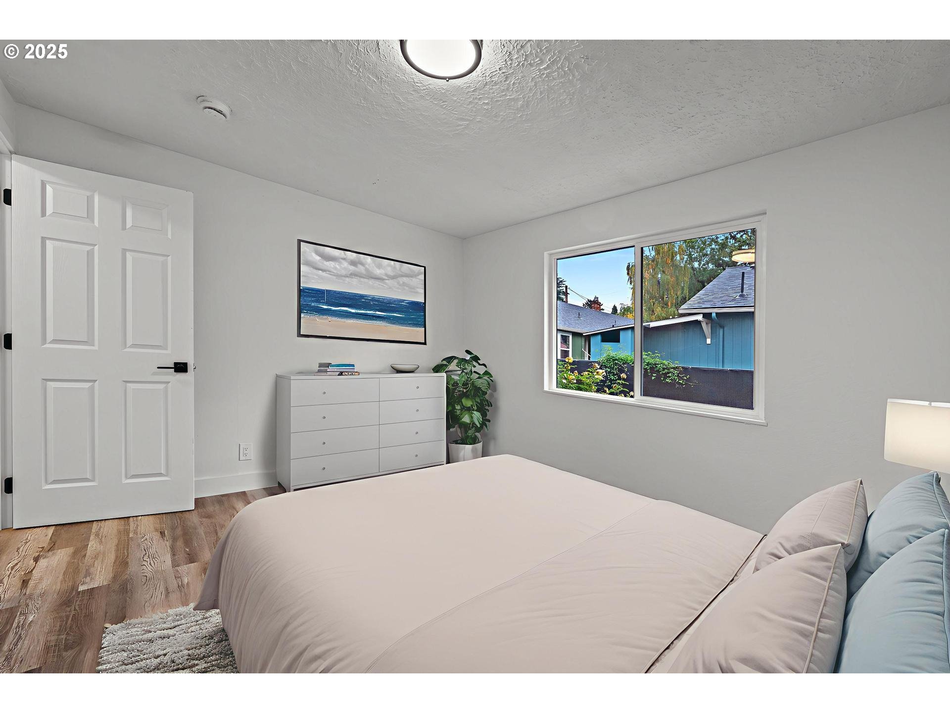 4804-4806 Northeast 111th Avenue Portland, OR 97220 - Photo 37 of 44 a bedroom with a bed and a painting on the wall