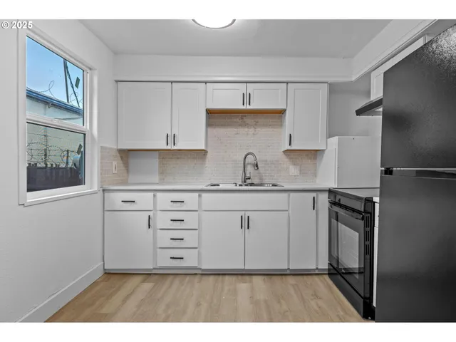 a kitchen with granite countertop white cabinets and stainless steel appliances