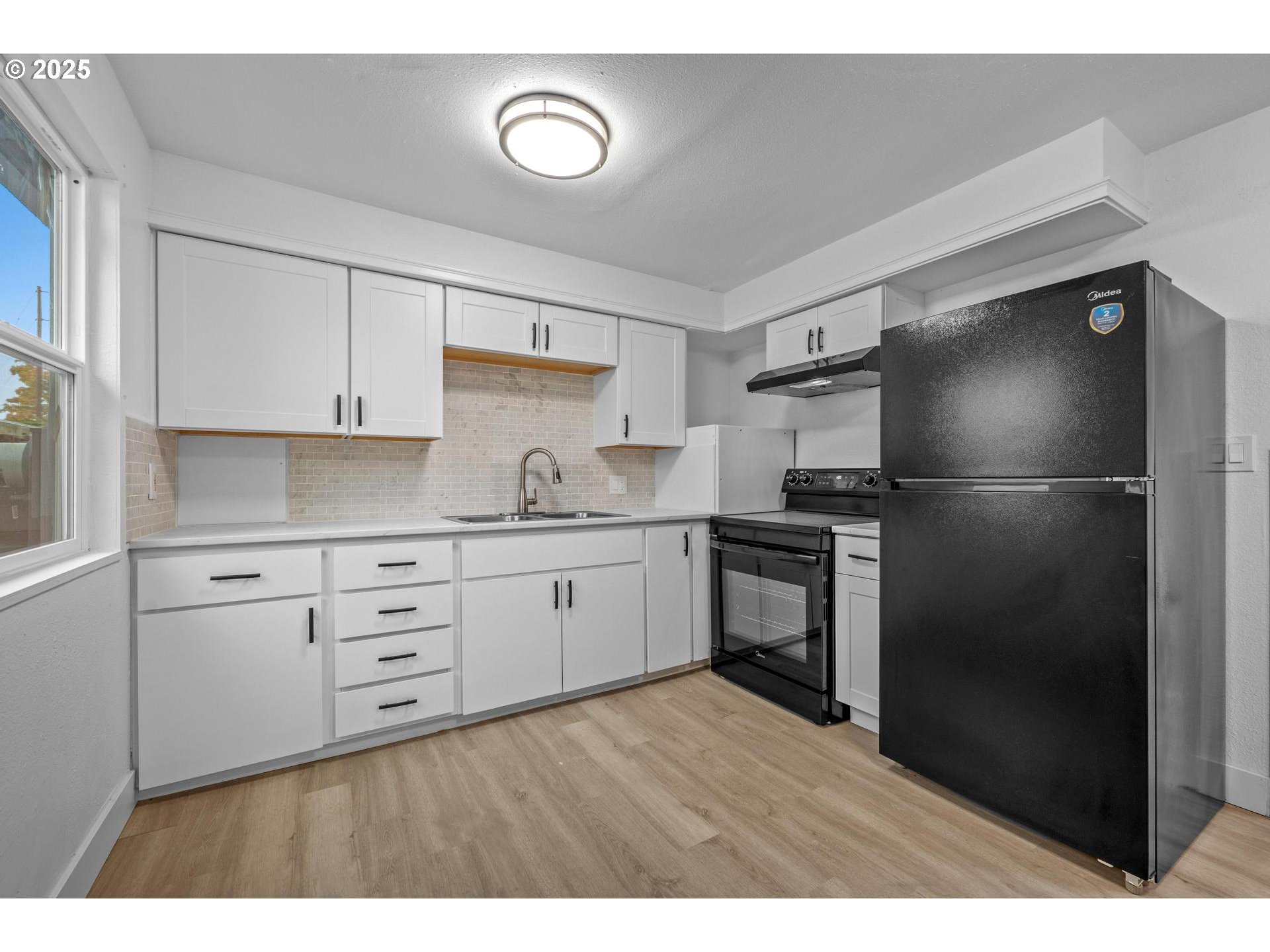 4804-4806 Northeast 111th Avenue Portland, OR 97220 - Photo 8 of 44 a kitchen with a refrigerator stove and white cabinets