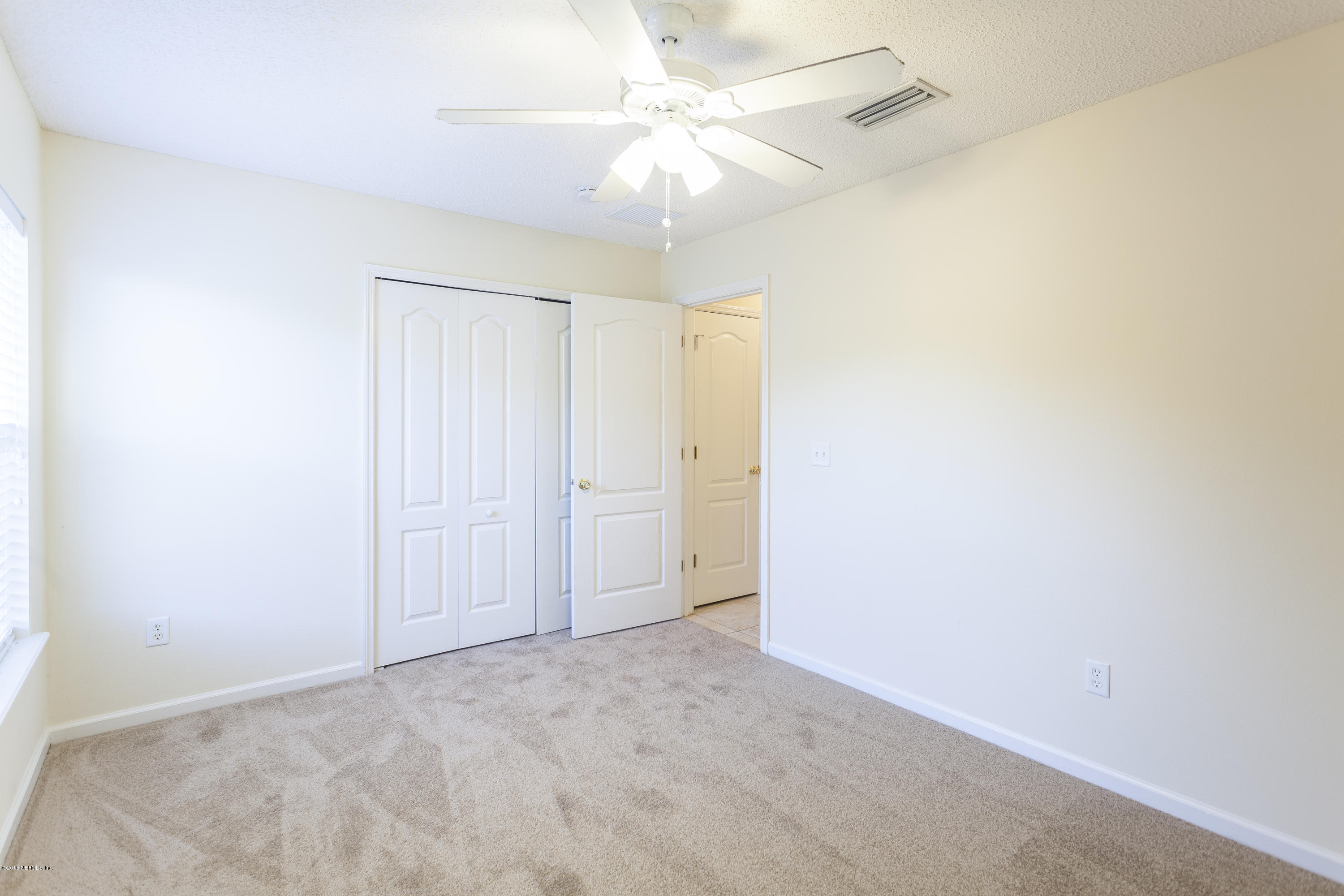 1148 Morning Light Road Jacksonville, FL 32218 - Photo 21 of 28 an empty room with a chandelier fan and closet