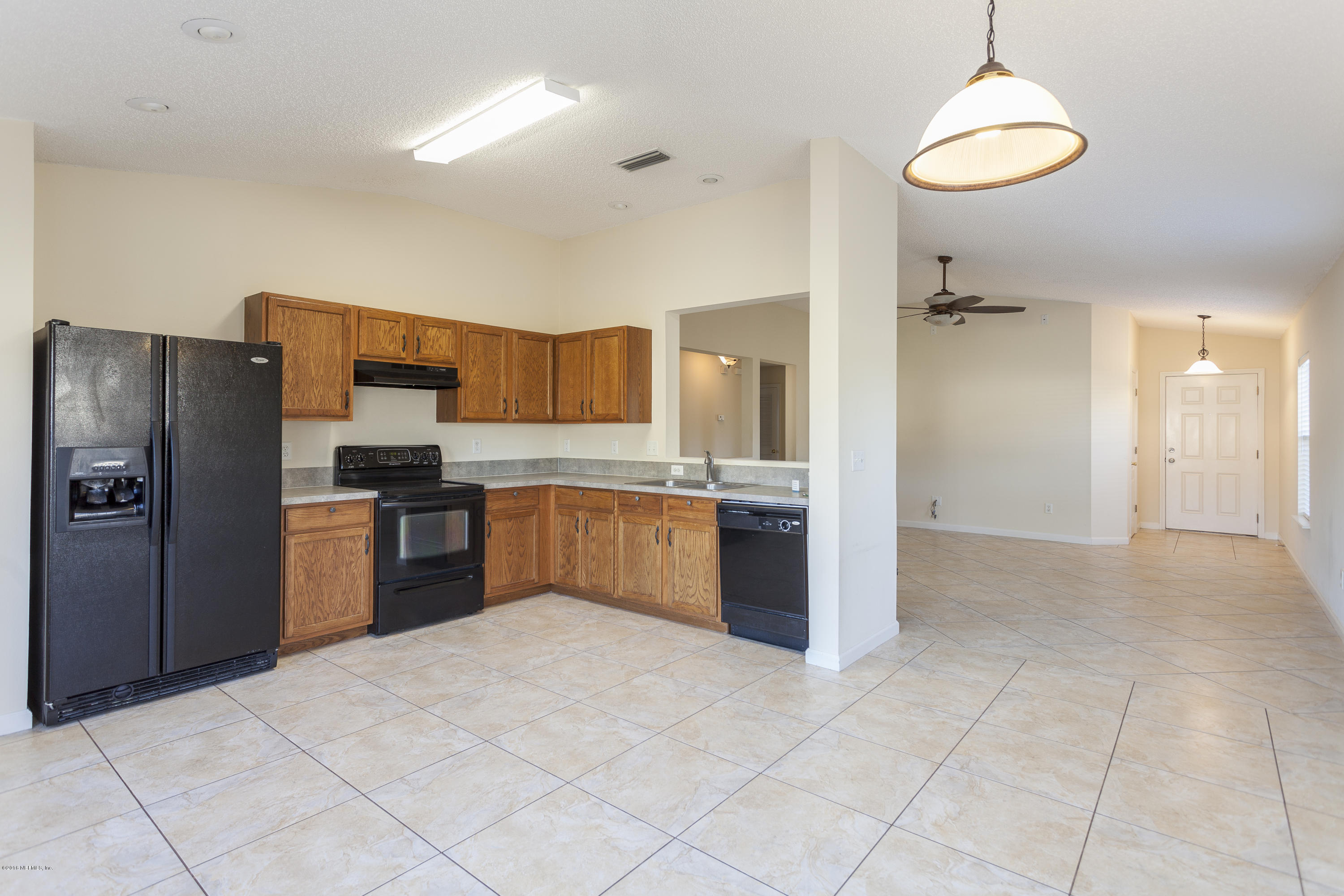 1148 Morning Light Road Jacksonville, FL 32218 - Photo 3 of 28 a kitchen with granite countertop a refrigerator and a stove top oven