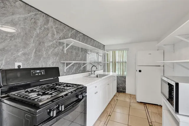 a stove top oven sitting inside of a kitchen