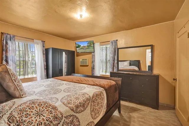 a bedroom with a bed and a large mirror on the dresser