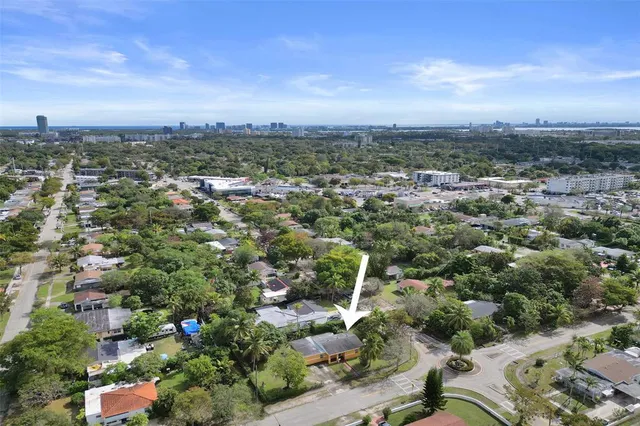 an aerial view of residential houses with outdoor space and trees
