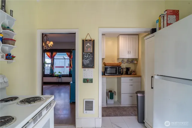 a kitchen view with a stove a refrigerator and a view of living room