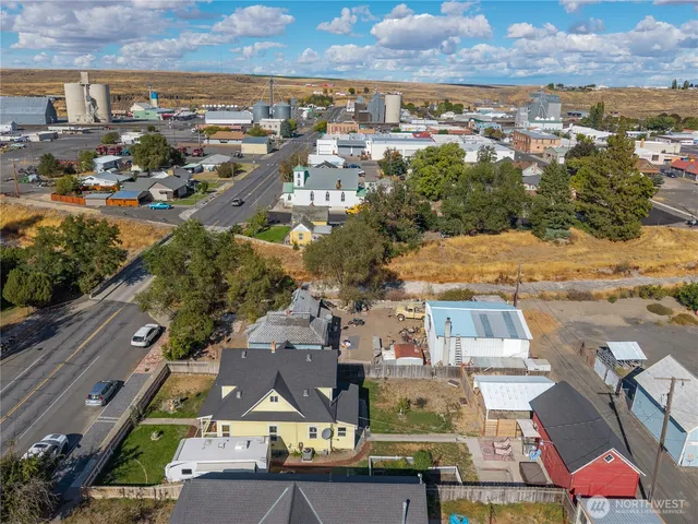 an aerial view of a city with lots of residential buildings ocean and mountain view in back