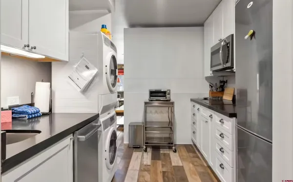 a kitchen with white cabinets and black appliances
