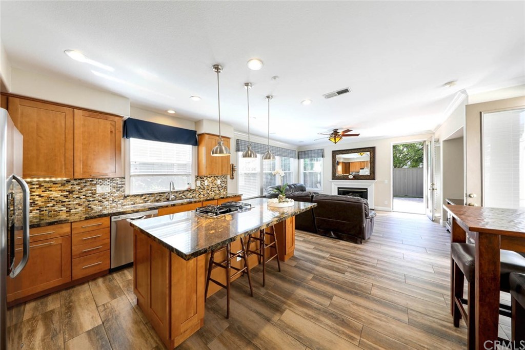 22 Calle Clasico San Clemente, CA 92673 - Photo 8 of 48 a kitchen with stainless steel appliances granite countertop a stove top oven a refrigerator a sink and white cabinets with wooden floor