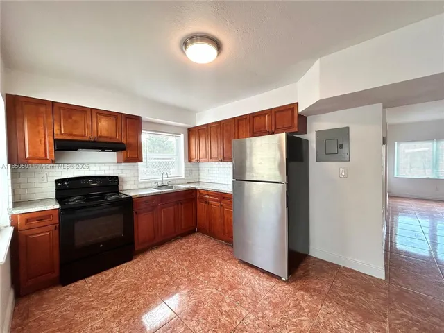a kitchen with a refrigerator and a stove top oven