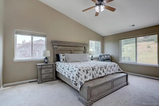 a bedroom with a large bed a flat tv screen and a chandelier
