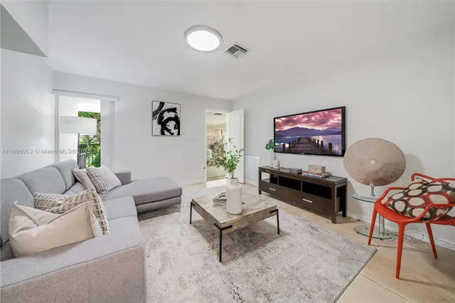 a living room with furniture a rug and a flat screen tv