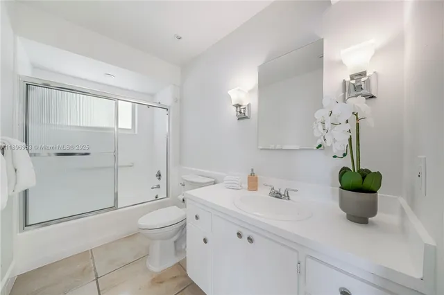 a bathroom with a granite countertop sink a toilet and shower