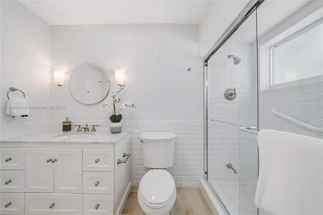 a bathroom with a toilet a sink and mirror