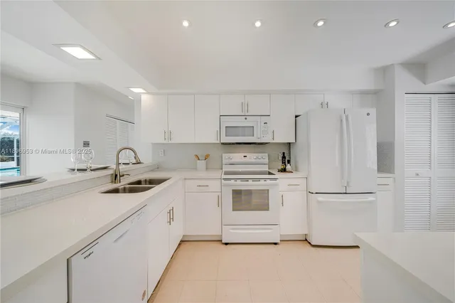 a kitchen with white cabinets stainless steel appliances and sink