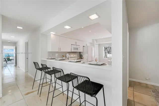 a kitchen with a dining table chairs and wooden floor