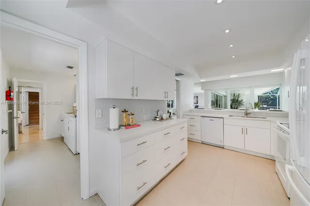 a kitchen with white cabinets and white appliances