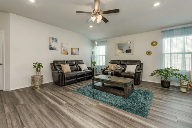 a living room with furniture and wooden floor