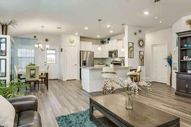 a living room with lots of furniture and kitchen view