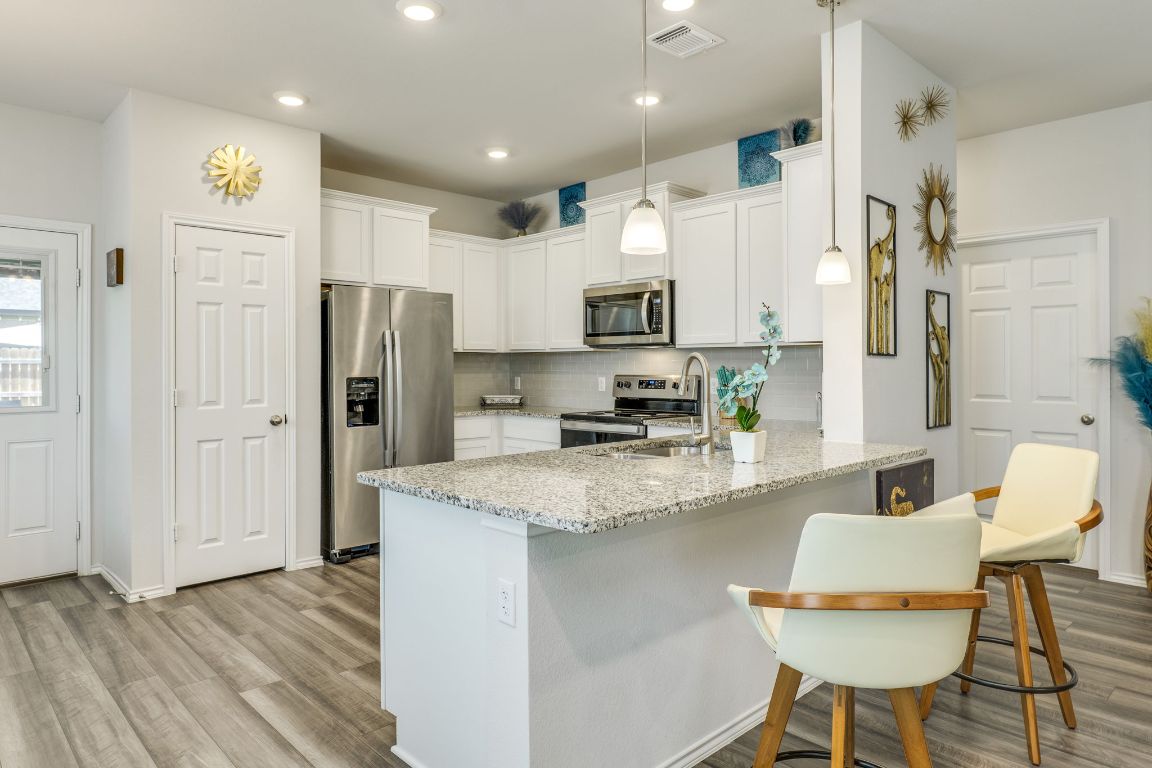 8932 Ranger Smt Road Temple, TX 76502 - Photo 15 of 40 a kitchen with stainless steel appliances granite countertop a refrigerator a sink a stove a dining table and chairs