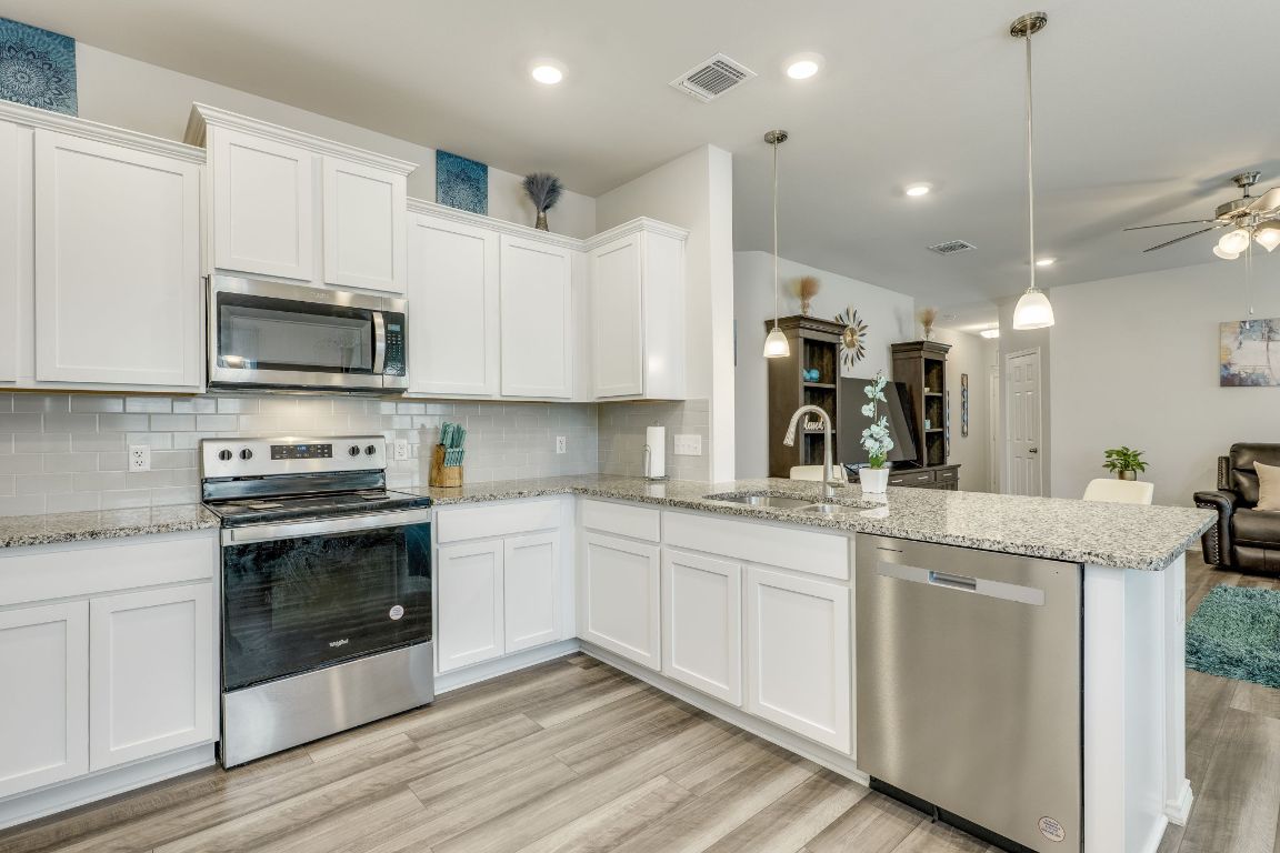 8932 Ranger Smt Road Temple, TX 76502 - Photo 18 of 40 a kitchen with stainless steel appliances granite countertop a stove top oven a sink and white cabinets