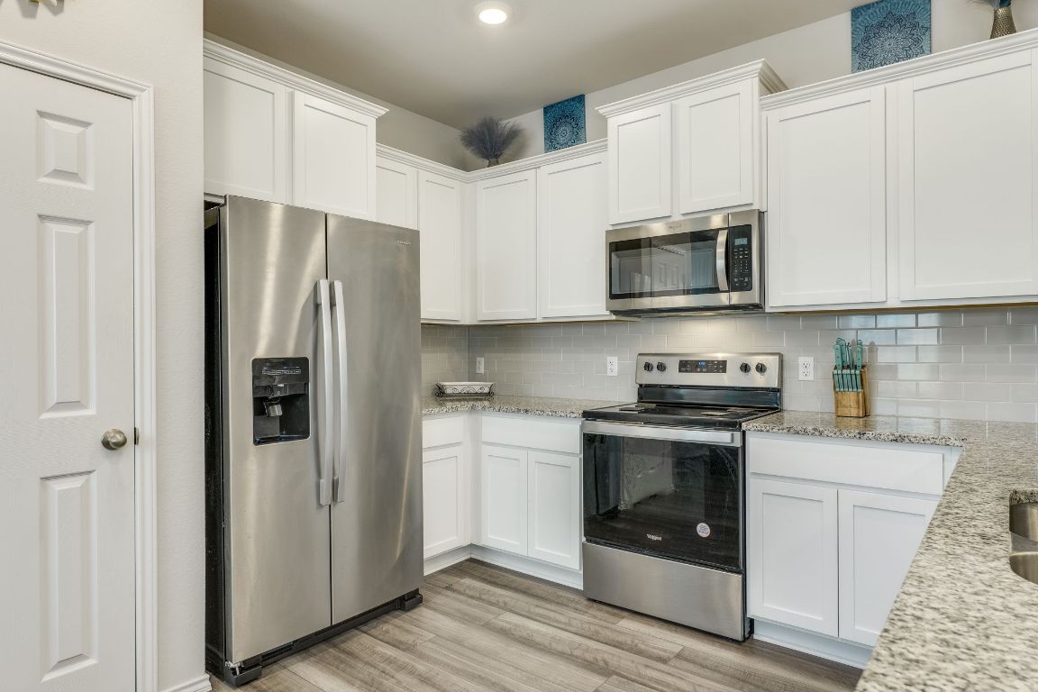 8932 Ranger Smt Road Temple, TX 76502 - Photo 19 of 40 a kitchen with stainless steel appliances granite countertop white cabinets a refrigerator a stove a microwave oven with white cabinets