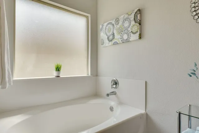 a white bath tub sitting next to a white wall