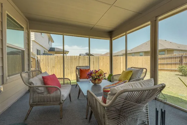 a living room with furniture and floor to ceiling windows