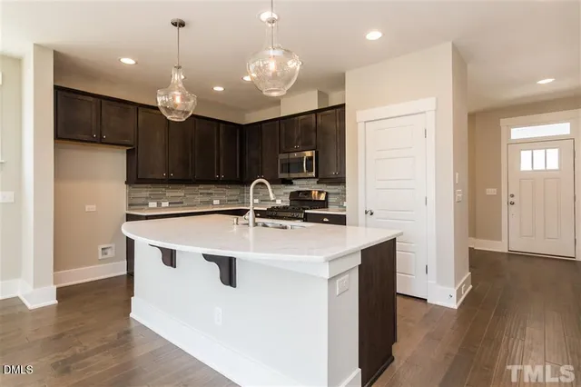 a kitchen with kitchen island a sink stainless steel appliances and cabinets