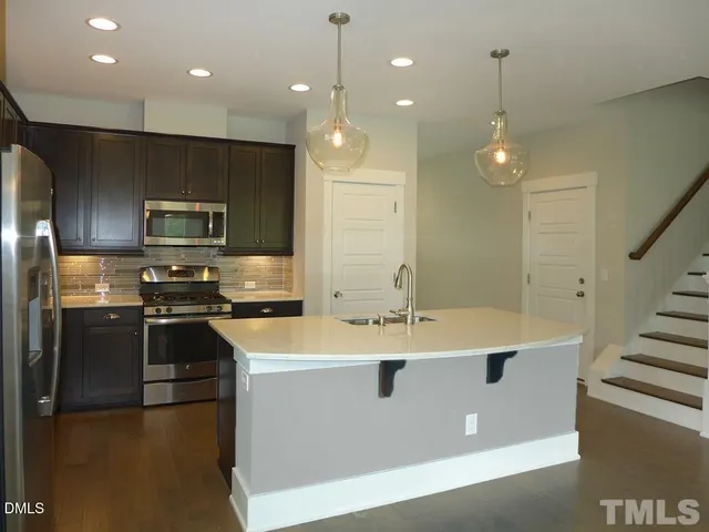 a kitchen with kitchen island a sink stainless steel appliances and cabinets
