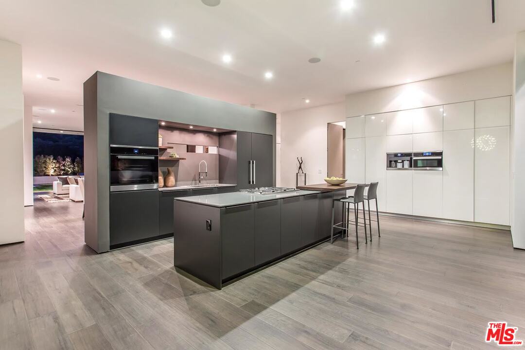 1424 Rising Glen Road Los Angeles, CA 90069 - Photo 6 of 48 a large kitchen with stainless steel appliances kitchen island granite countertop a large counter top and oven