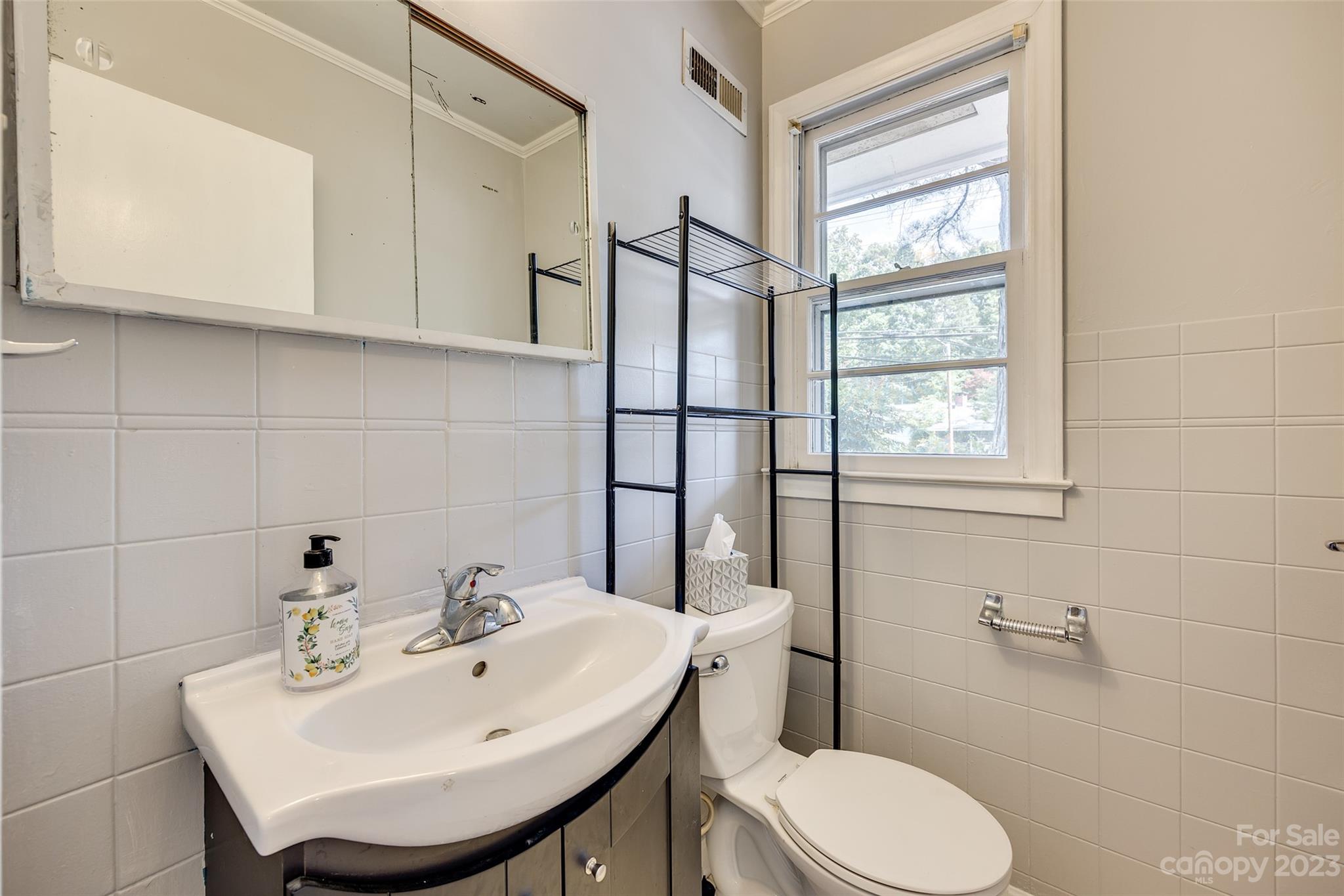 1136 East Woodlawn Road Charlotte, NC 28209 - Photo 5 of 27 a bathroom with a sink a toilet and mirror