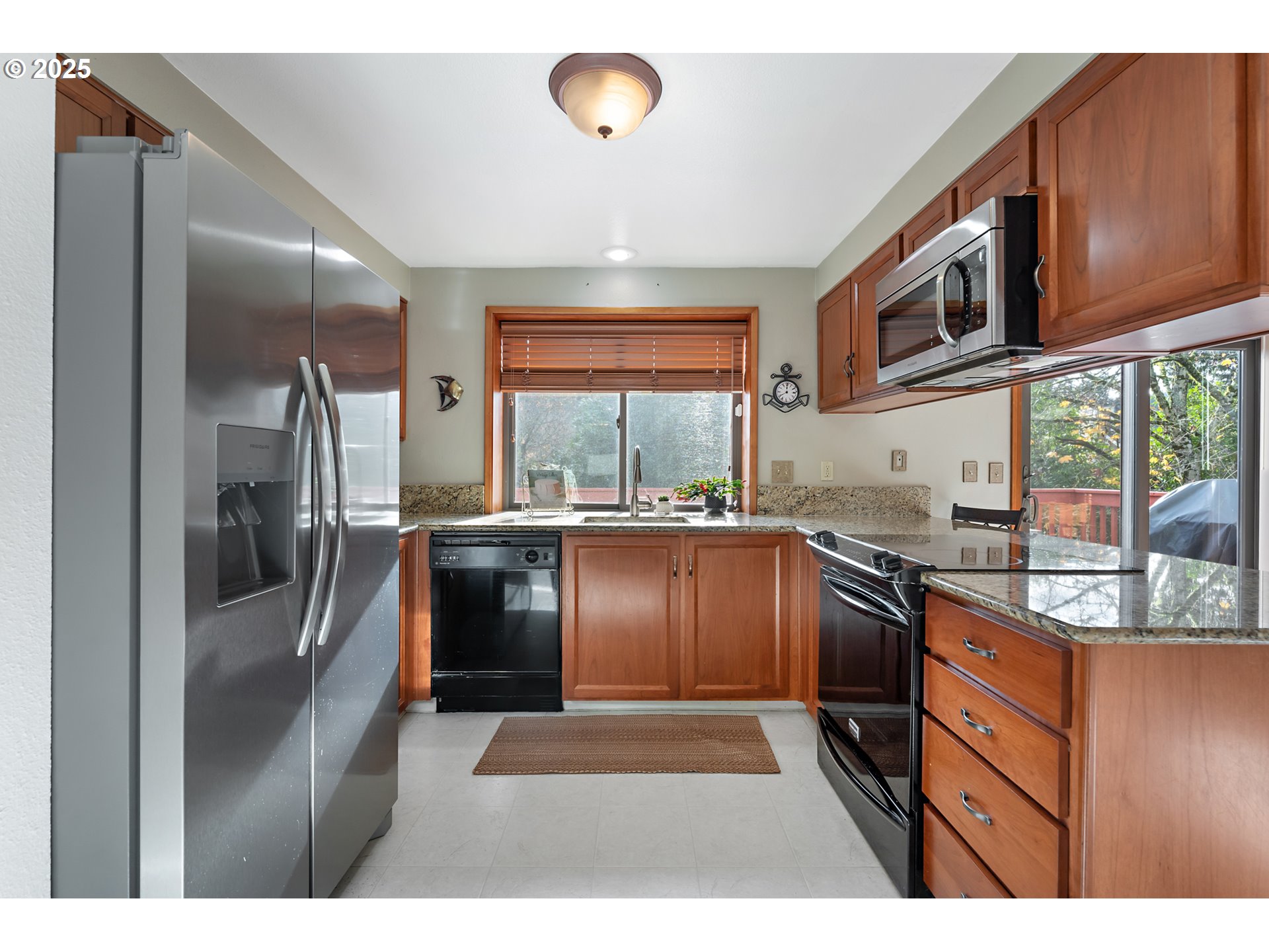 18100 Southwest Barcelona Way Beaverton, OR 97007 - Photo 13 of 41 a kitchen with stainless steel appliances granite countertop a refrigerator a stove and a sink