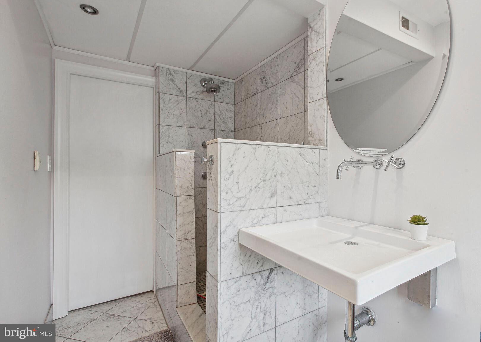 18 9th Street Northeast, Unit 401 Washington, DC 20002 - Photo 14 of 16 a bathroom with a sink and a mirror