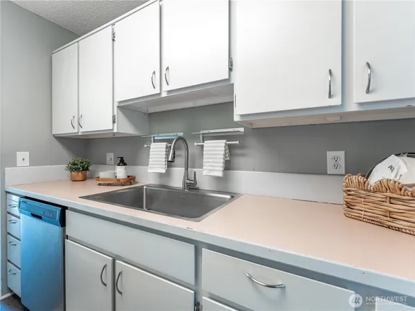 a bathroom with a granite countertop bathtub sink vanity mirror and toilet