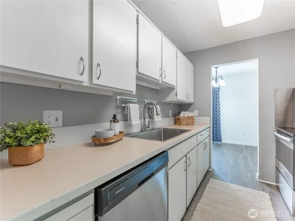 a view of a kitchen with wooden floor and cabinets